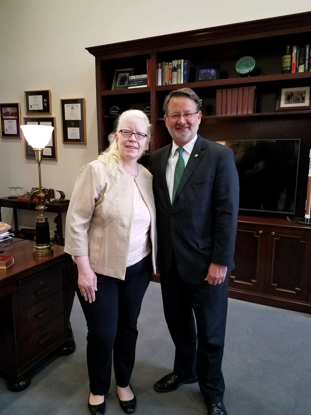 A picture of a man and a woman smiling in an office.