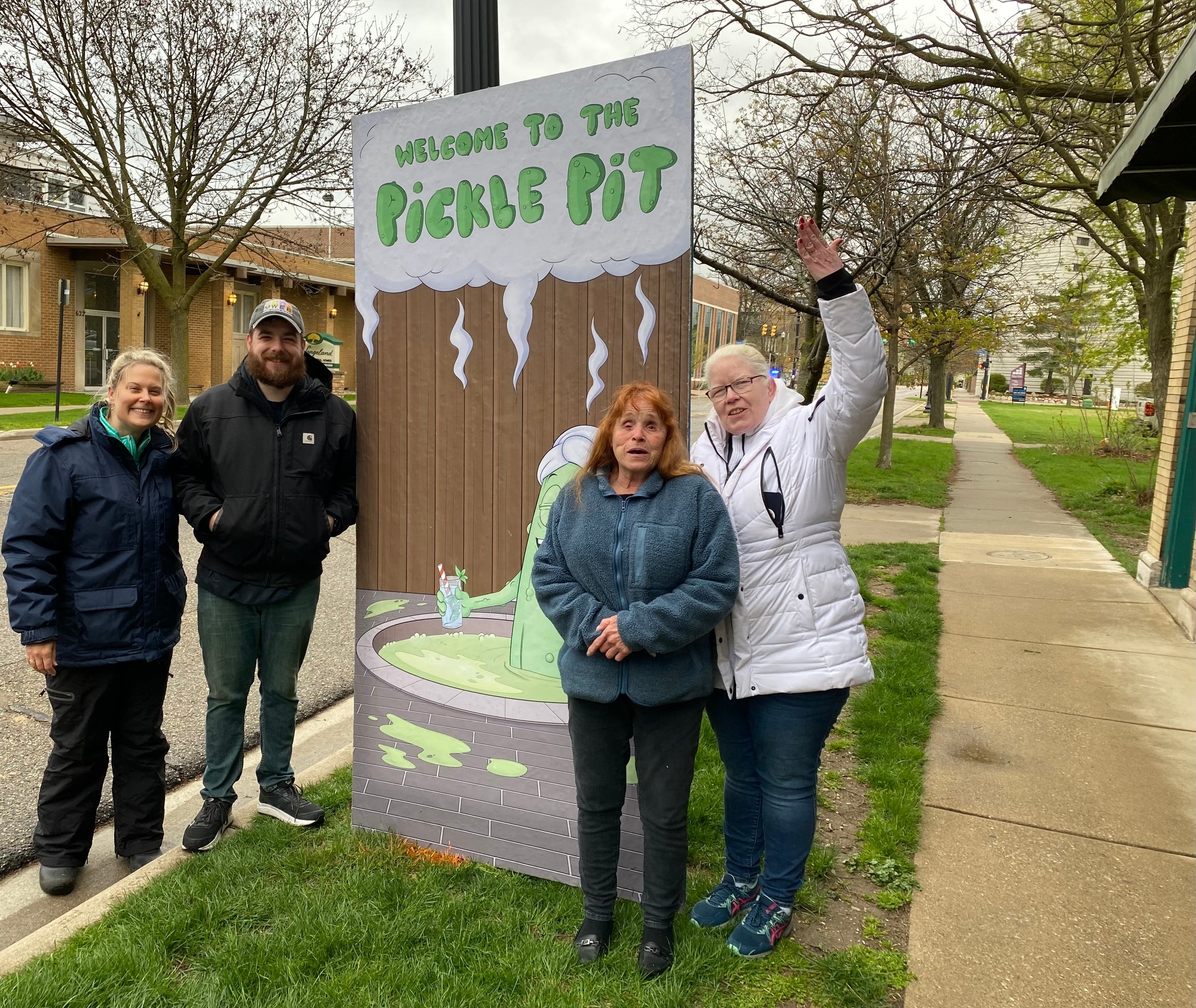 A picture of a group of people in front of a sign that says "Welcome to the Pickle Pit".