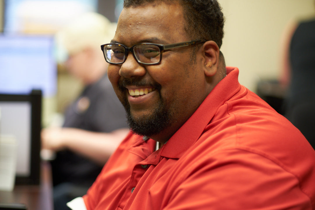 A man wearing a red shirt smiling.
