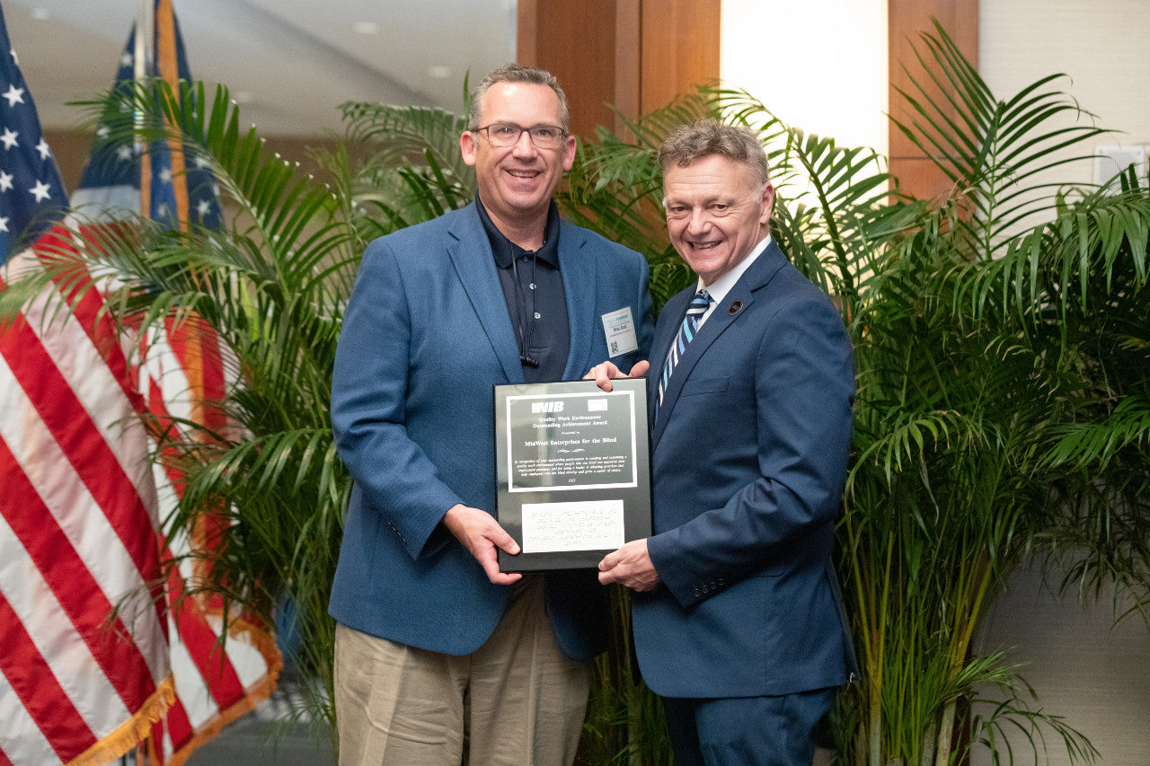 A picture of two men holding an award.