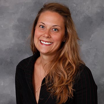 A woman wearing a black shirt and smiling.