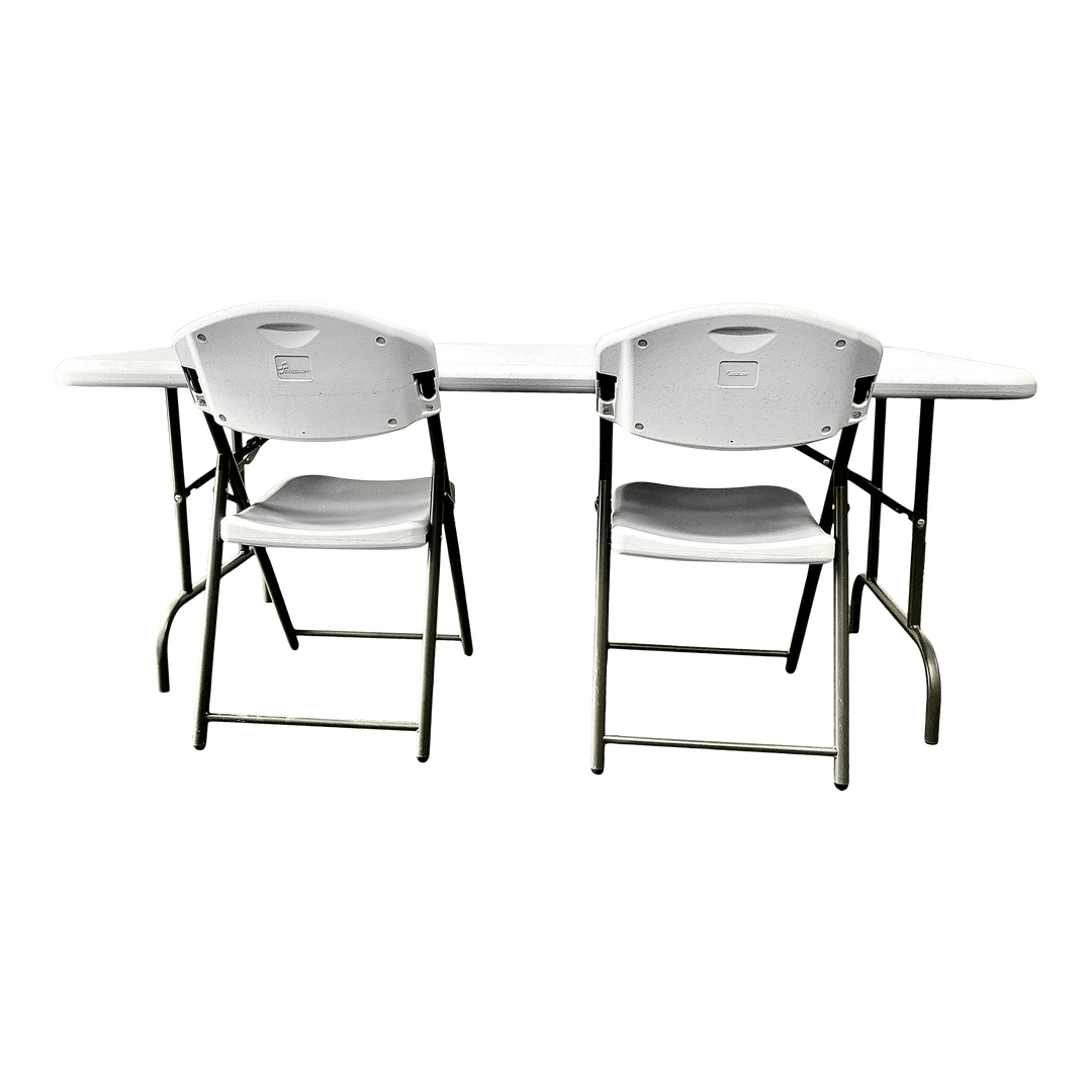 A picture of two platinum folding chairs in front of a platinum folding table.