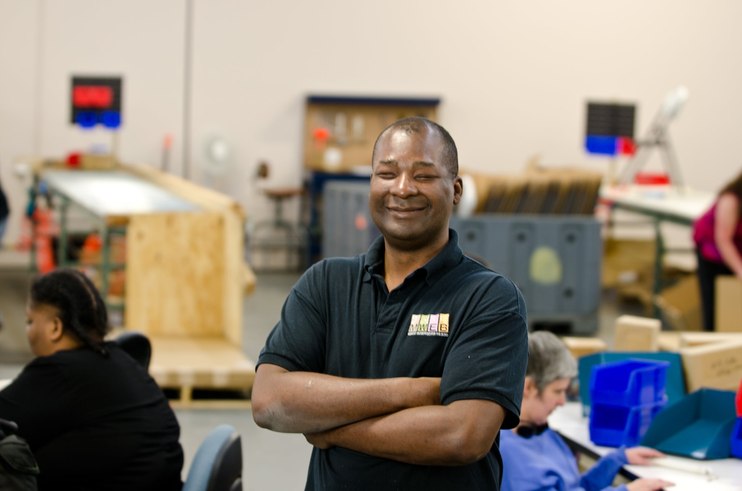 A picture of a smiling man in a warehouse. 